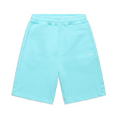 The 6PM+ SHORTS TURQUOISE by 6PM are light blue athletic shorts with a relaxed fit, elastic drawstring waist, side pockets, and a small white logo on one leg. Laid flat on white background, theyre perfect for lounging.