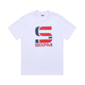 The GRAN TURISMO TEE WHITE by 6PM is a white short-sleeve t-shirt with a large, stylized red and navy “S” graphic and bold red SIXPM text outlined in blue below the design.