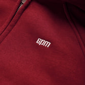 Close-up of the WMNS CROPPED ZIP HOODIE in wine red by 6PM, featuring a visible zipper and white embroidered 6PM branding on the chest.