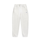 The 6PM CUFF JOGGER COCONUT WHITE features a classic fit, elastic waistband and cuffs, two side pockets, and a small blue logo on the upper left thigh. Shown laid flat on a white background.