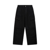The 6PM ZIP-OFF CARGO BLACK pants feature a straight-leg fit, multiple flap pockets on the thighs and knees, belt loops at the waistband, and a button closure. Shown laid flat on a white background.