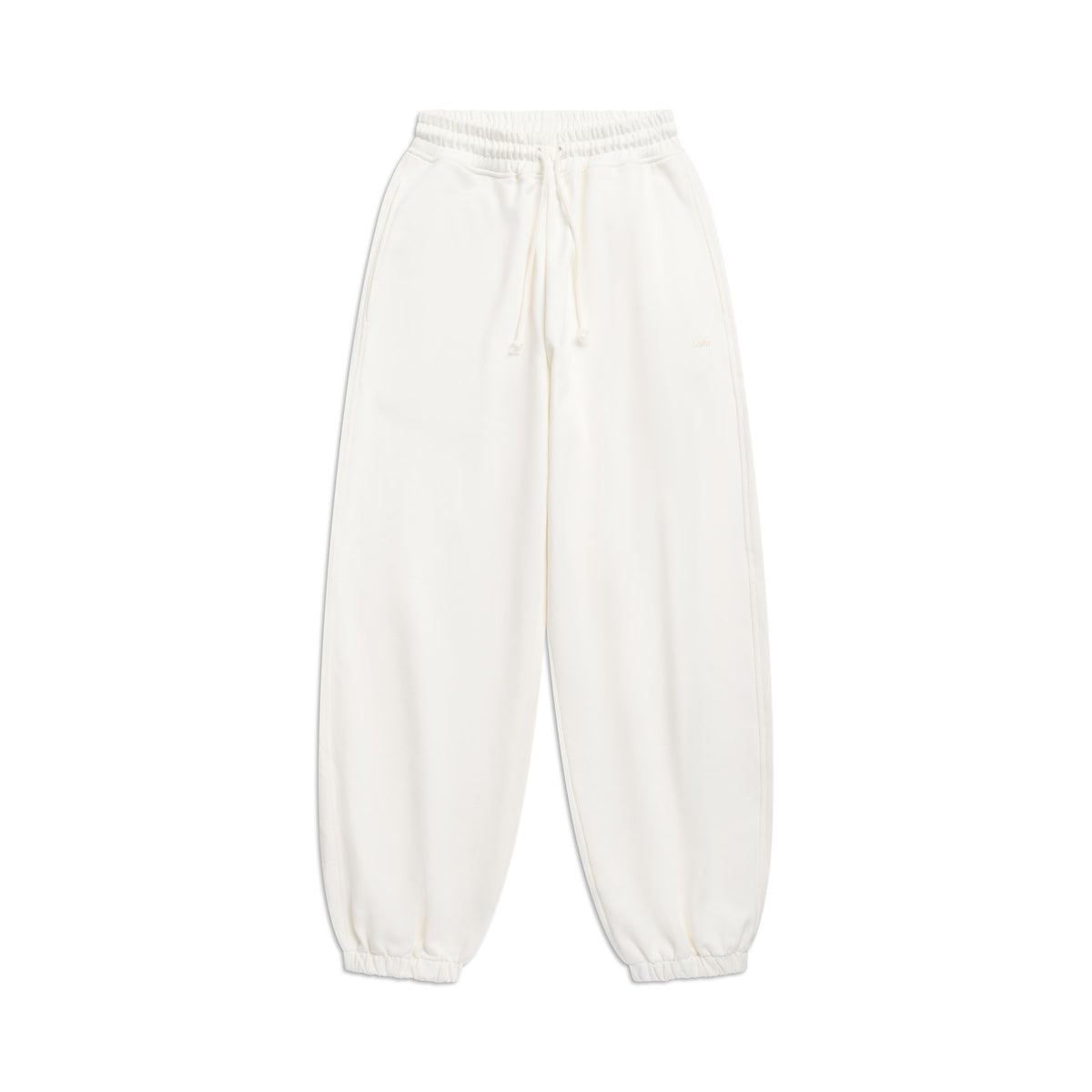 The 6PM SUPER WIDE JOGGER COCONUT WHITE features an elastic waistband with drawstring, side pockets, and elastic ankle cuffs, shown laid flat on a white background.
