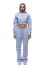 A woman faces forward in a 6PM WMNS Cropped Zip Hoodie Soft Violet with matching sweatpants and white sneakers. Her hair is braided, her expression neutral, and the background is white.