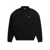 The 6PM POLO BLACK is a plain black long-sleeve polo shirt with a collar, three buttons, ribbed cuffs, and a small white logo on the left chest, shown against a white background.