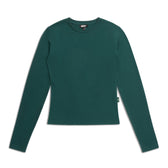 The 6PM WMNS LONGSLEEVE EVERGREEN is a fitted, forest green women’s crew neck shirt with long sleeves, shown laid flat on a white background and featuring a small tag on the left side seam.
