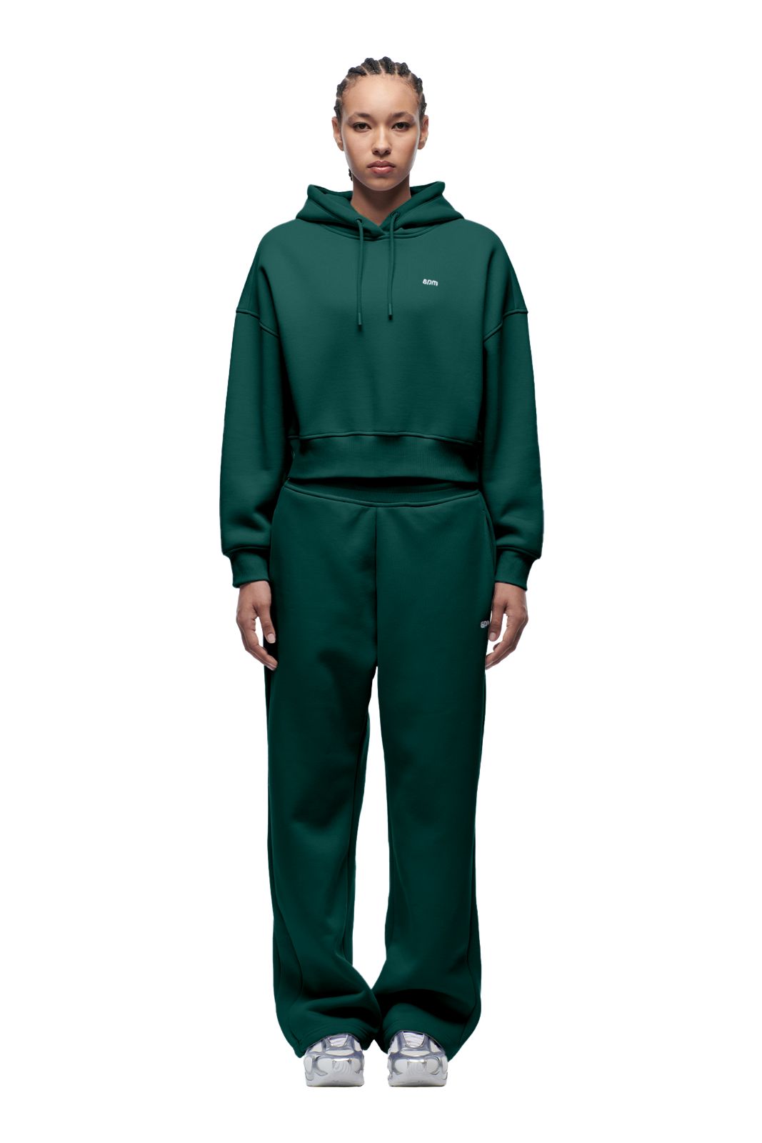 A person faces forward against a plain white background, wearing the 6PM WMNS CROPPED HOODIE EVERGREEN with matching wide-leg sweatpants and white sneakers.